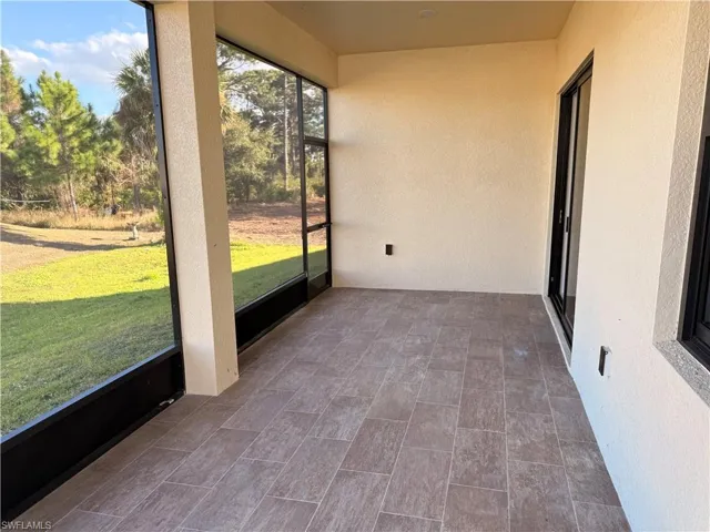 Unfurnished sunroom with a textured wall