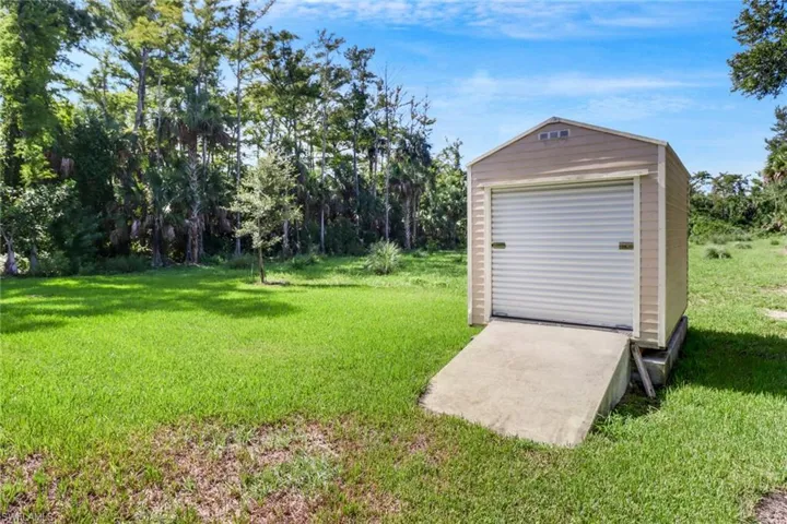 View of yard with a garage and an outbuilding