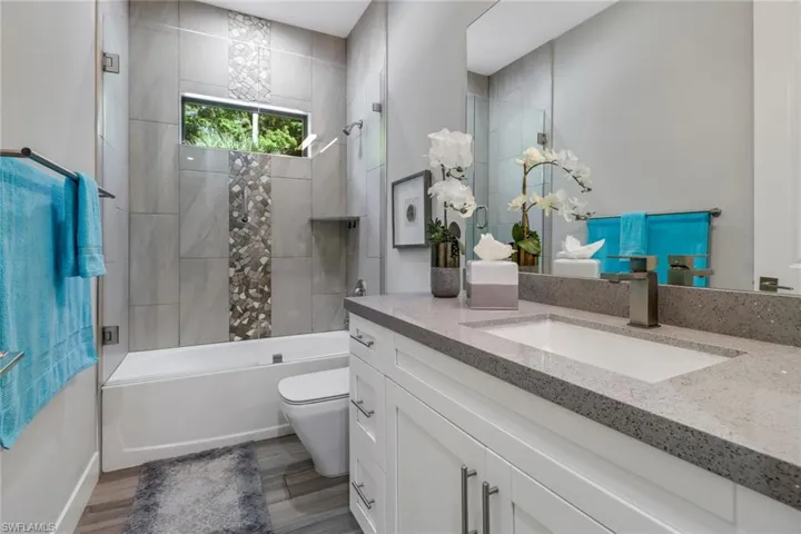 Full bathroom with vanity, toilet, and tiled shower / bath
