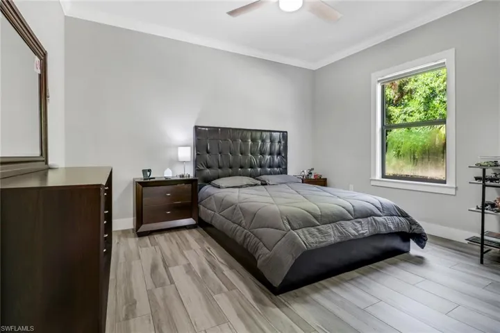Bedroom with ceiling fan, crown molding, and light hardwood / wood-style flooring
