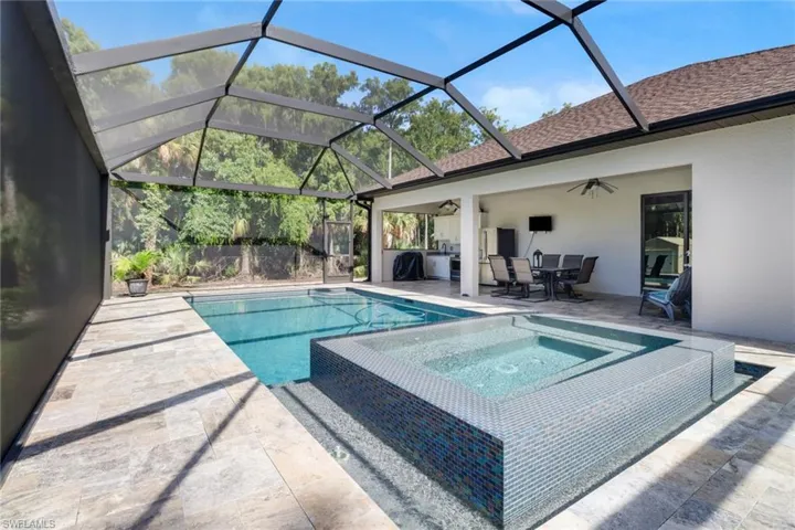 View of swimming pool with a lanai, a patio, an in ground hot tub, and ceiling fan