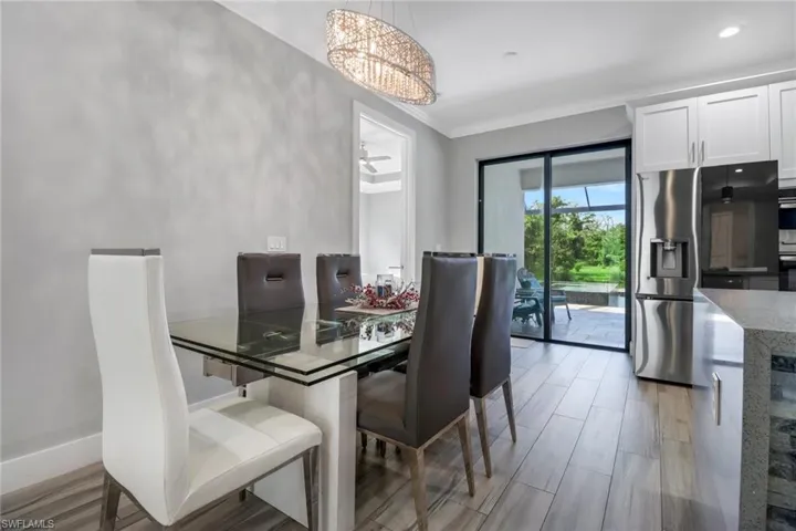 Dining area with a chandelier, crown molding, and light hardwood / wood-style floors