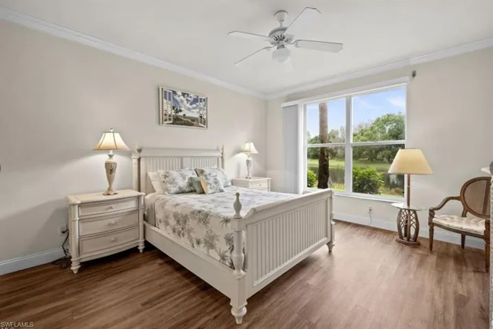 Bedroom featuring ceiling fan, dark hardwood / wood-style flooring, and crown molding