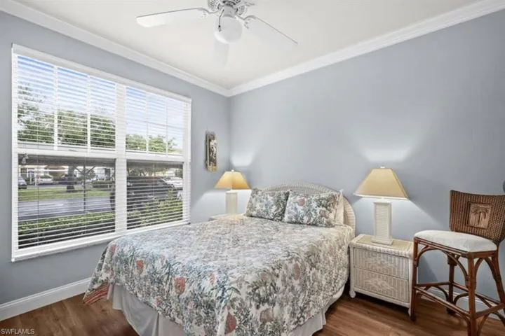 Bedroom with crown molding, ceiling fan, and hardwood / wood-style floors