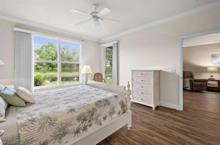 Bedroom with ornamental molding, dark hardwood / wood-style floors, and ceiling fan