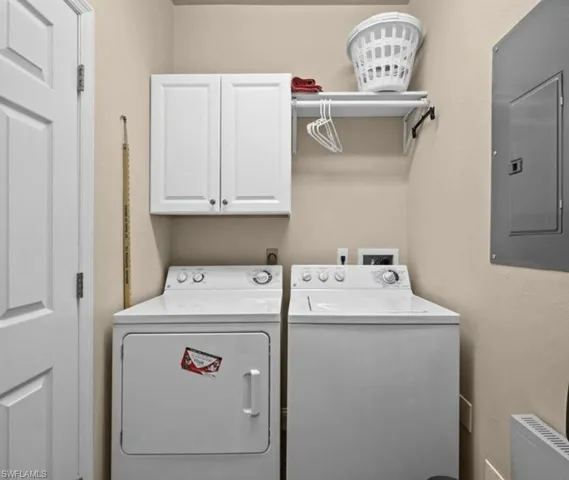 Washroom with hookup for a washing machine, washer and dryer, radiator heating unit, and cabinets