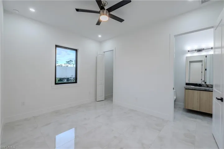 Bathroom with a marble finish shower, double vanity, and light tile patterned flooring