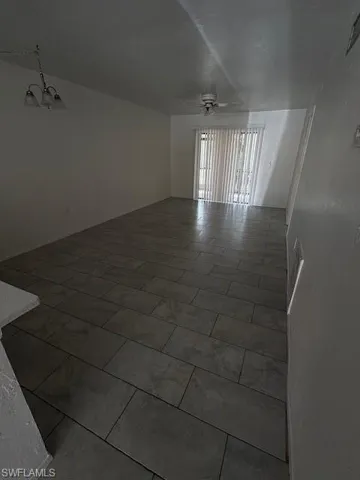 Spare room featuring ceiling fan and a chandelier