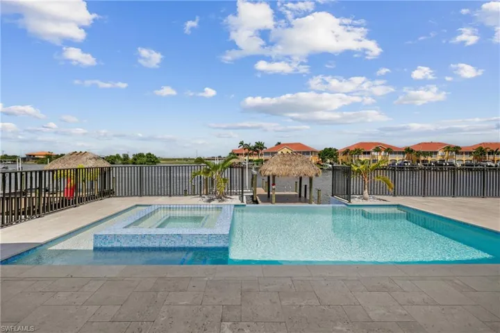 View of pool with a water view, a pool with connected hot tub, a gazebo, and a patio