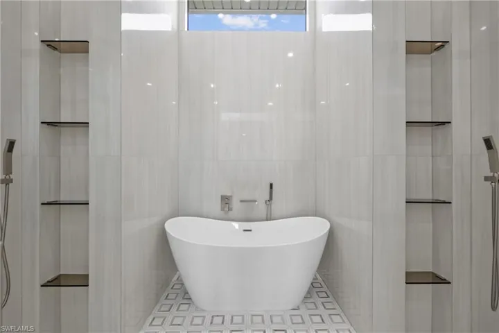 Bathroom featuring a freestanding bath and tile walls