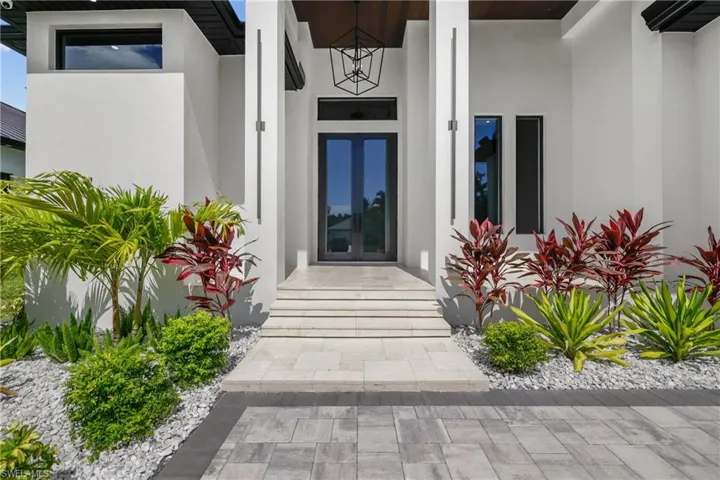 Doorway to property featuring french doors and stucco siding