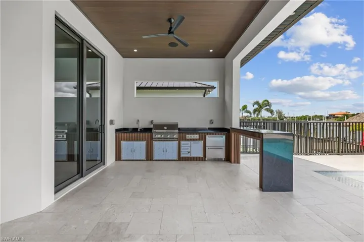 View of patio with exterior kitchen and a ceiling fan