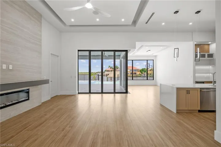 Unfurnished living room featuring light wood-style flooring, a fireplace, a ceiling fan, and recessed lighting