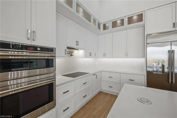 Kitchen featuring stainless steel appliances, light countertops, white cabinetry, and light wood-style flooring
