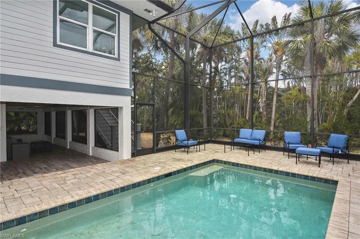View of swimming pool featuring a lanai, outdoor lounge area, and a patio