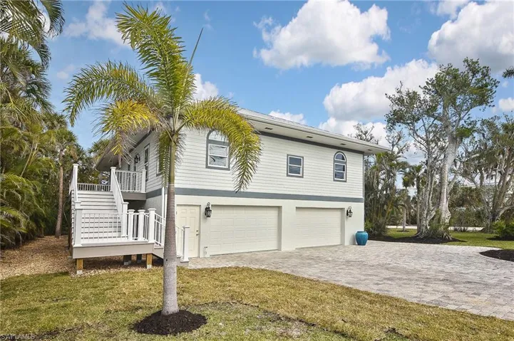 View of side of property with a yard and a garage