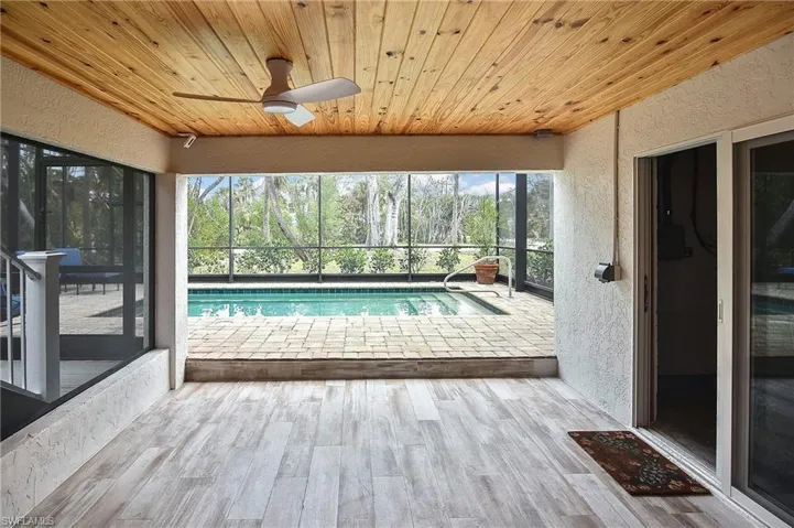 View of swimming pool with ceiling fan, a lanai, and a patio area