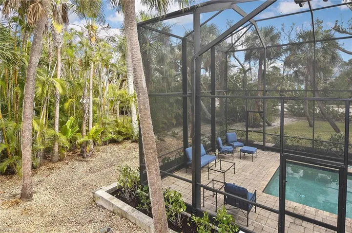 View of swimming pool featuring a patio area and glass enclosure