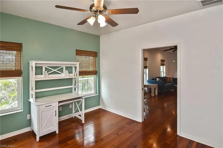 Office area with ceiling fan and dark hardwood / wood-style floors