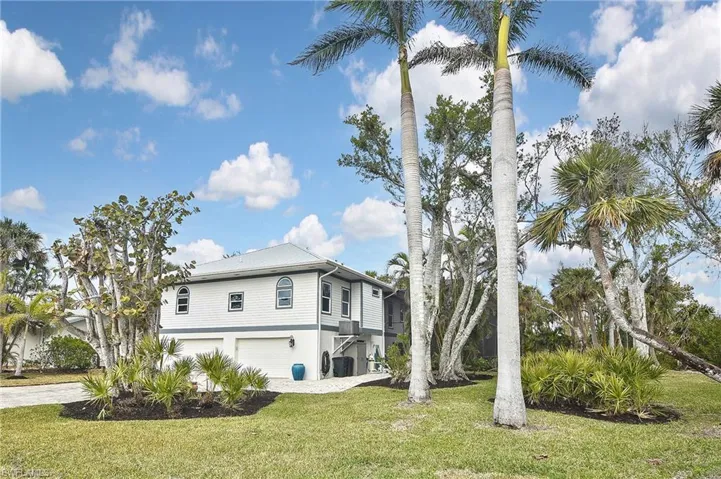 View of property exterior with a garage and a yard