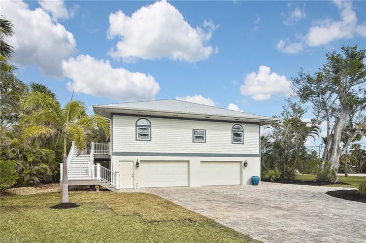 View of property exterior featuring a garage and a lawn