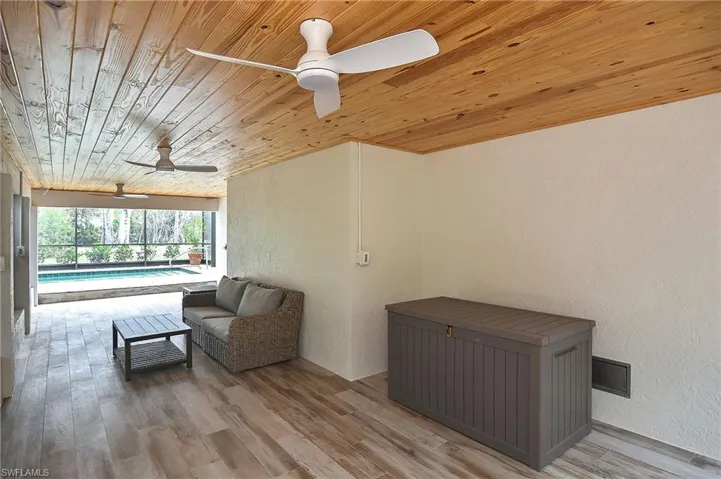 Sitting room featuring a swimming pool, wood ceiling, light hardwood / wood-style floors, and ceiling fan