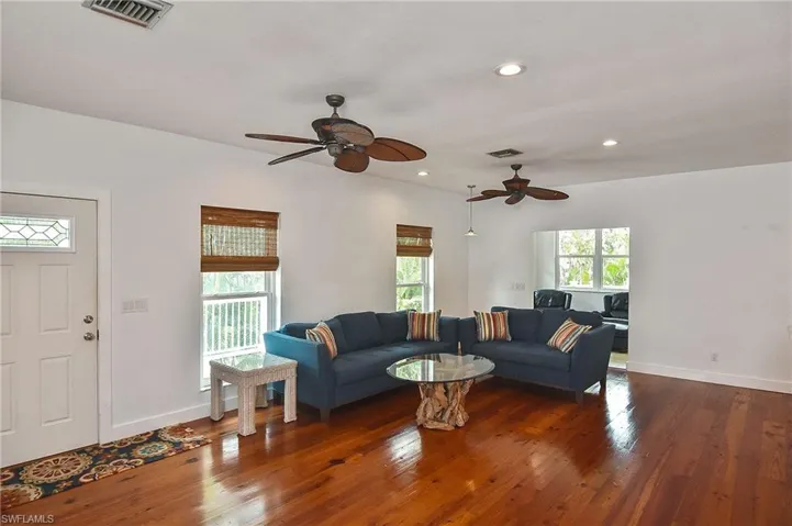 Living room with dark wood-type flooring and ceiling fan
