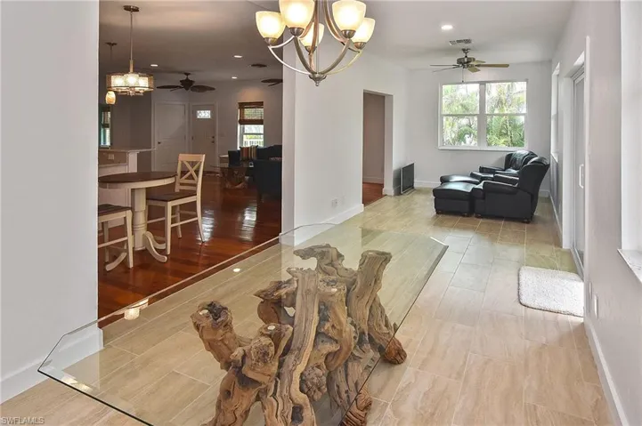 Living room with ceiling fan with notable chandelier
