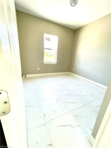 Empty room with baseboards and light marble finish floors