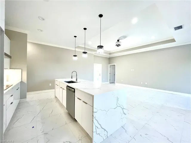 Kitchen featuring white cabinets, modern cabinets, crown molding, light stone countertops, and light marble finish floors