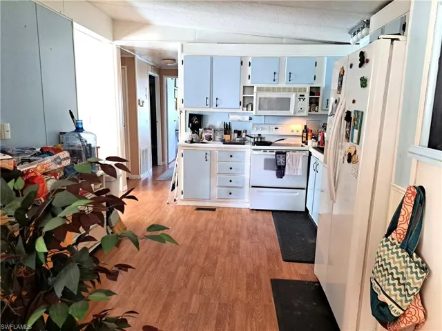 Kitchen with white appliances and light wood-type flooring