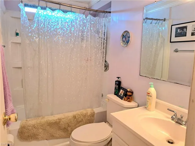 Full bathroom featuring shower / tub combo, vanity, and toilet