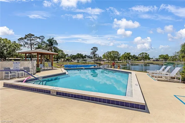 View of swimming pool with a gazebo, a patio area, and a water view