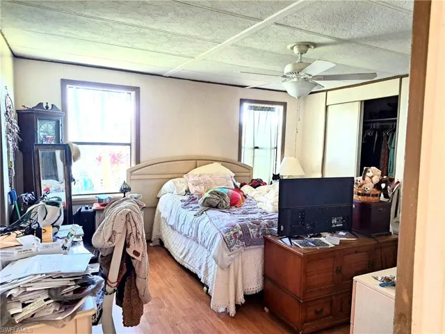 Bedroom featuring hardwood / wood-style flooring, ceiling fan, and a closet