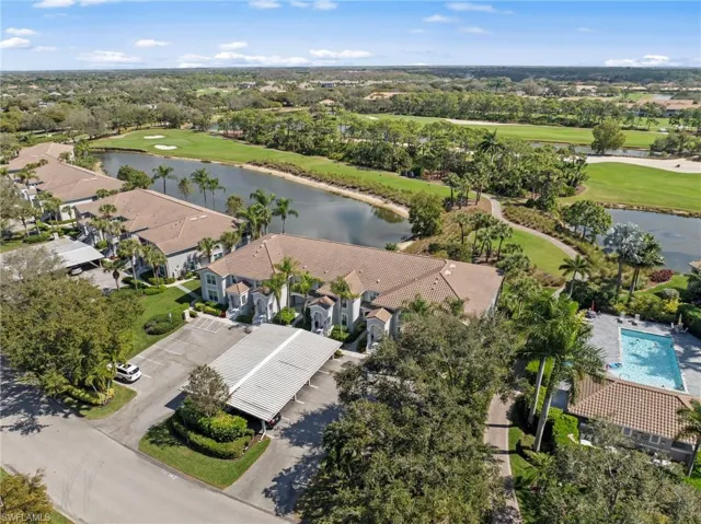 Aerial view of residential area featuring a nearby body of water and a golf course