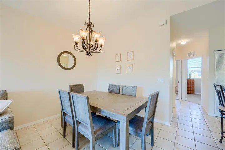 Tiled dining room with a chandelier