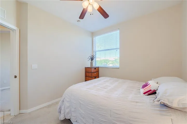 Bedroom with ceiling fan and light colored carpet