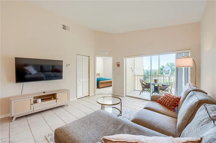 Living room with a high ceiling and light tile patterned flooring
