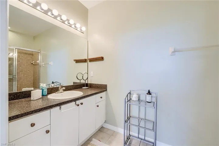 Bathroom with tile patterned flooring, vanity, and walk in shower