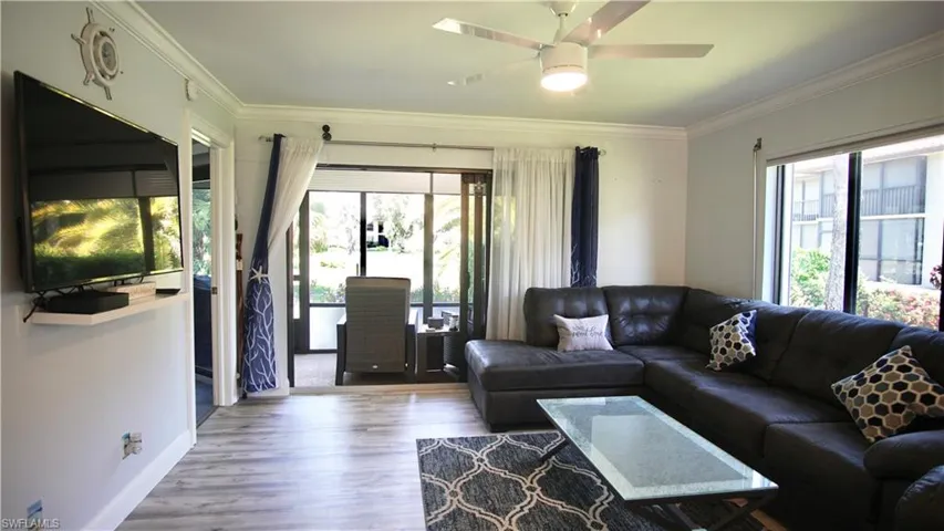 Living room with ceiling fan, hardwood / wood-style flooring, and ornamental molding