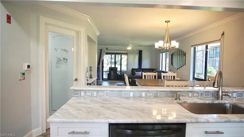 Kitchen featuring a wealth of natural light, white cabinets, and sink
