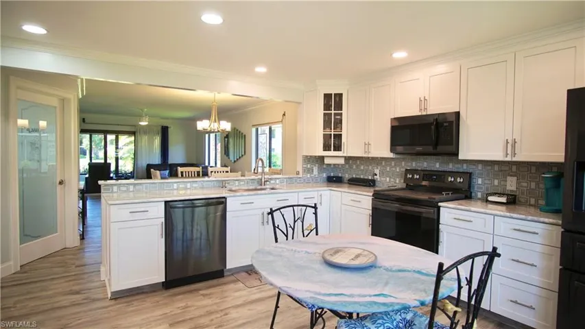 Kitchen featuring a chandelier, light hardwood / wood-style flooring, stainless steel dishwasher, sink, and electric stove