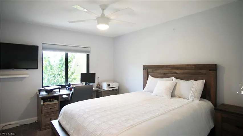 Carpeted bedroom featuring ceiling fan