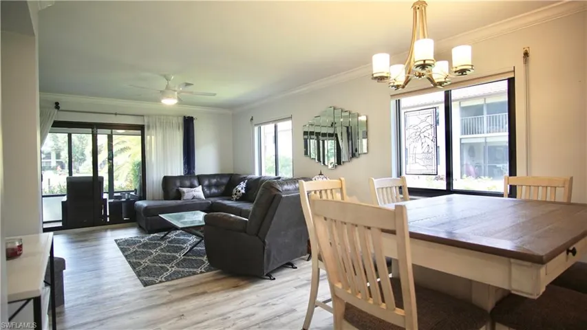 Dining area featuring hardwood / wood-style floors, ornamental molding, and ceiling fan with notable chandelier