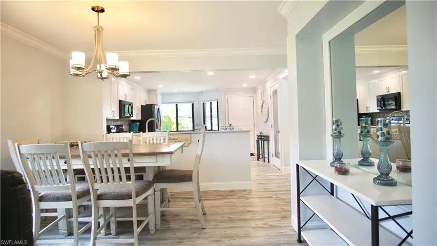 Dining room featuring a chandelier, crown molding, and light hardwood / wood-style flooring