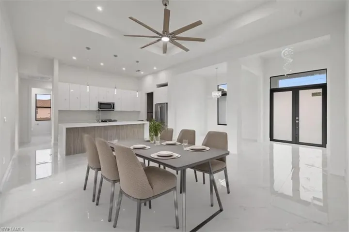 Dining area featuring french doors, ceiling fan, and a tray ceiling