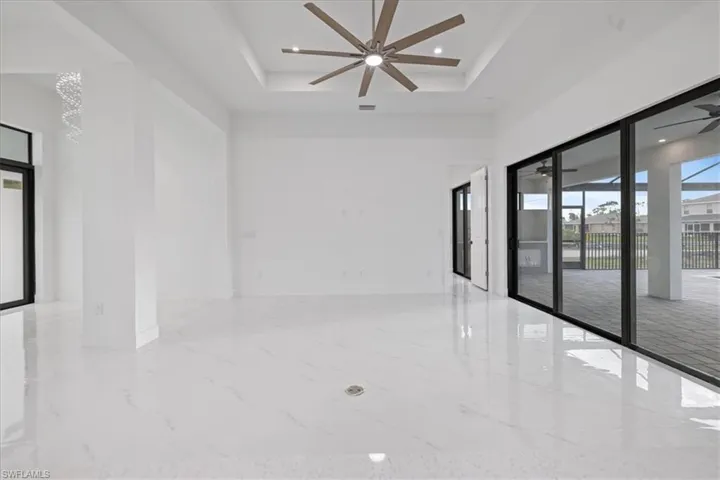 Unfurnished room featuring ceiling fan and a tray ceiling