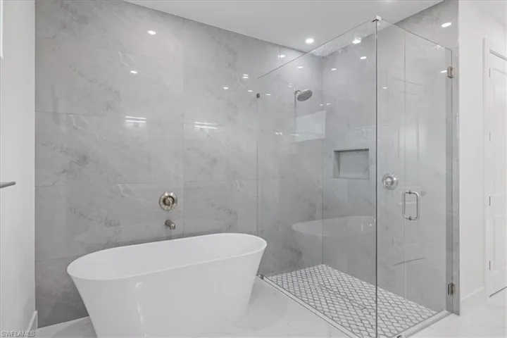 Bathroom featuring shower with separate bathtub