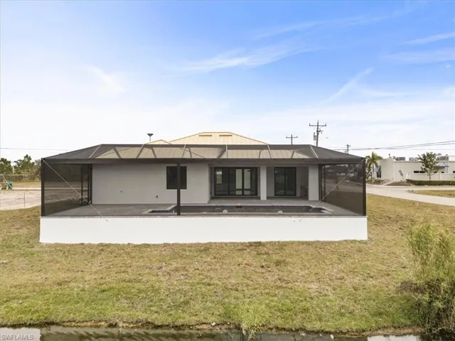 Back of property featuring a patio, a yard, and glass enclosure