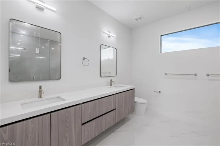 Bathroom with vanity, a shower, and toilet